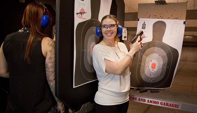 
              Tanya Morris, right, poses for a photo with her shot-up target after getting married at the Guns and Ammo Garage, Thursday, Feb. 14, 2013, in Las Vegas. Las Vegas is embracing tourists